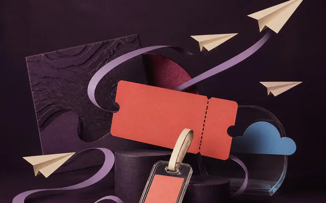 Editorial travel composition with paper planes, a luggage tag, and a coral ticket.