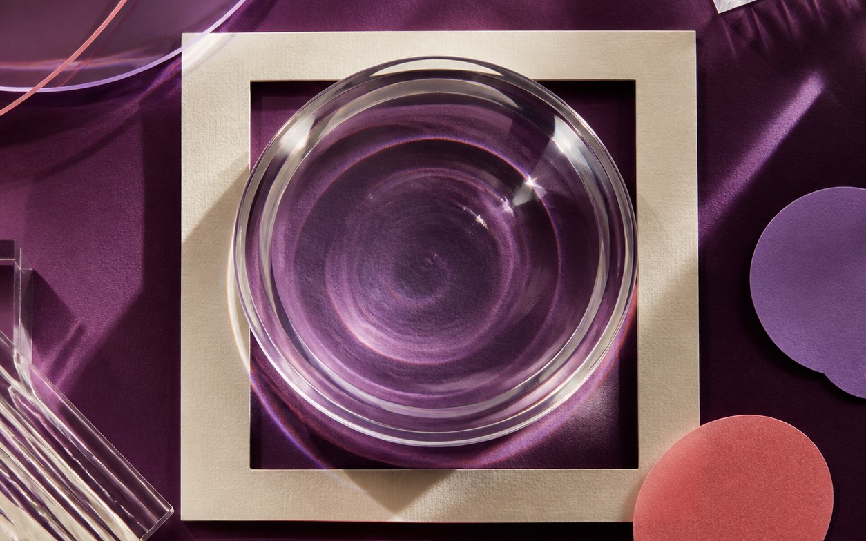 Editorial optical composition with a clear lens, cream frame, and conversation forms.